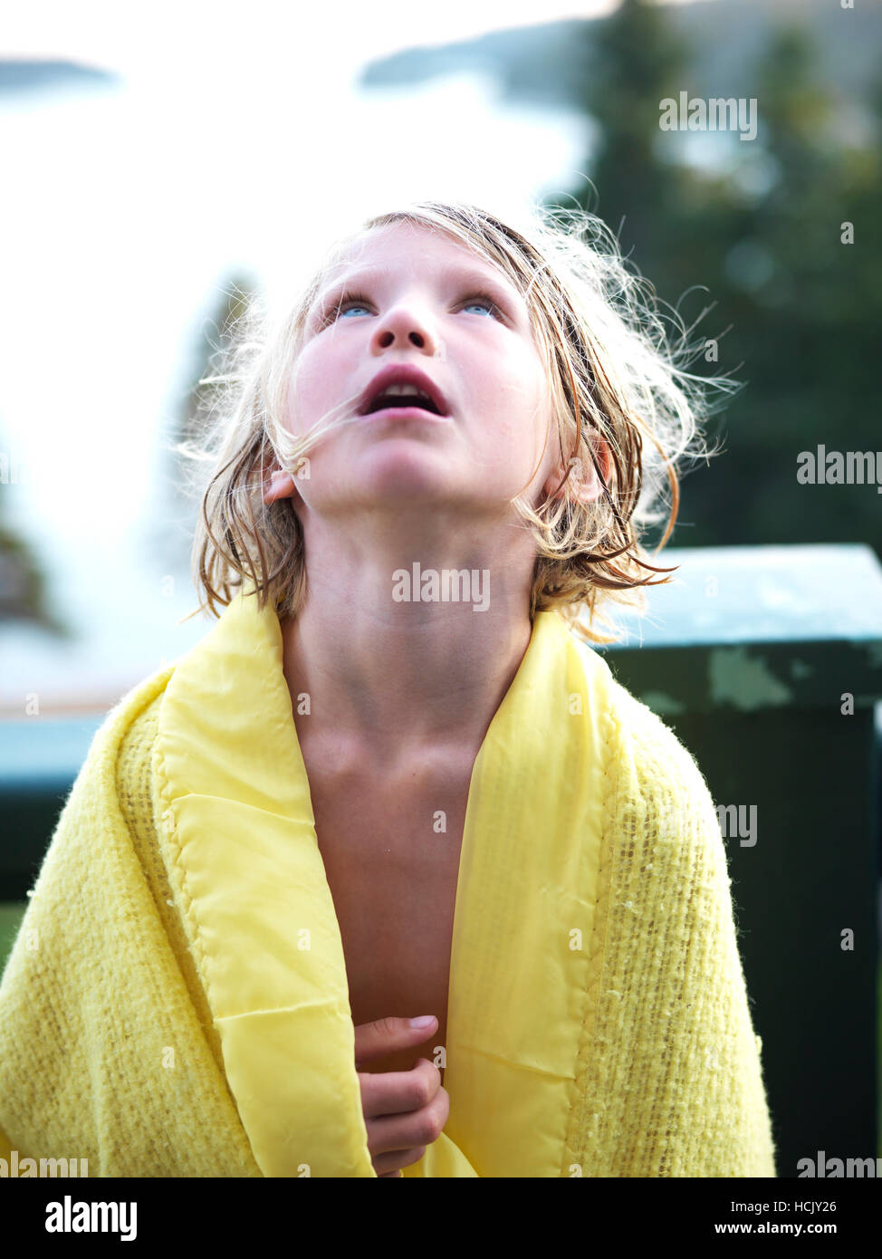 Une jeune fille, enveloppée dans une couverture, regarde vers le ciel sur  un porche sur la côte du Maine Photo Stock - Alamy