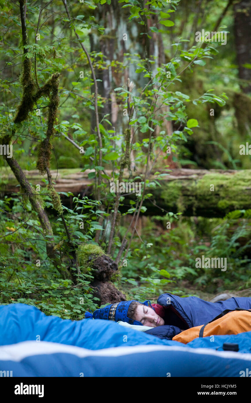 Podell-Eberhardt Zach dort sur le sol dans son sac de couchage à sept milles et demi de camp, sur le sentier du ruisseau Eagle, Columbia River Gorge National Scenic Area, Oregon. Banque D'Images