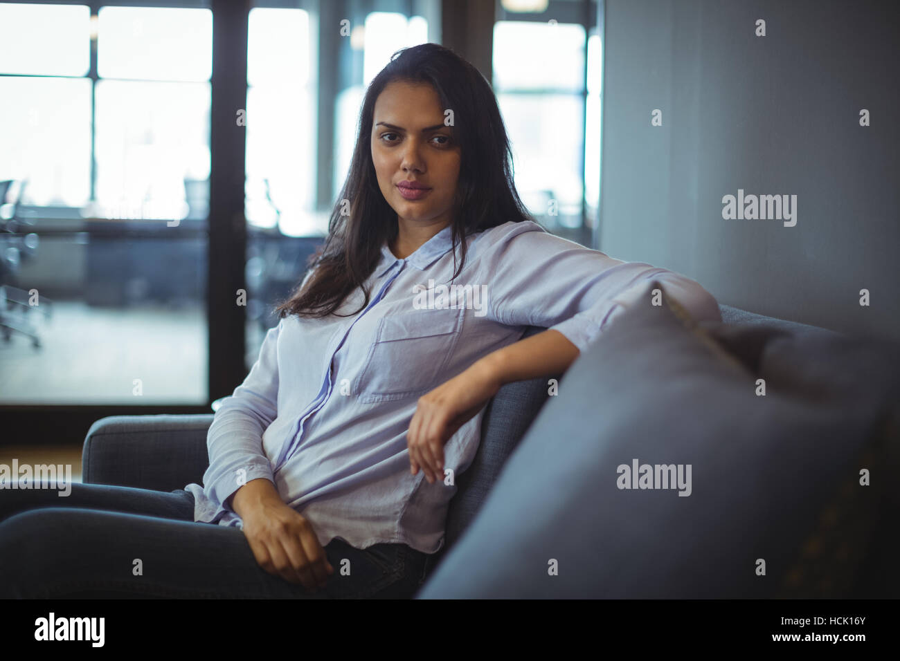 Woman sitting on sofa Banque D'Images