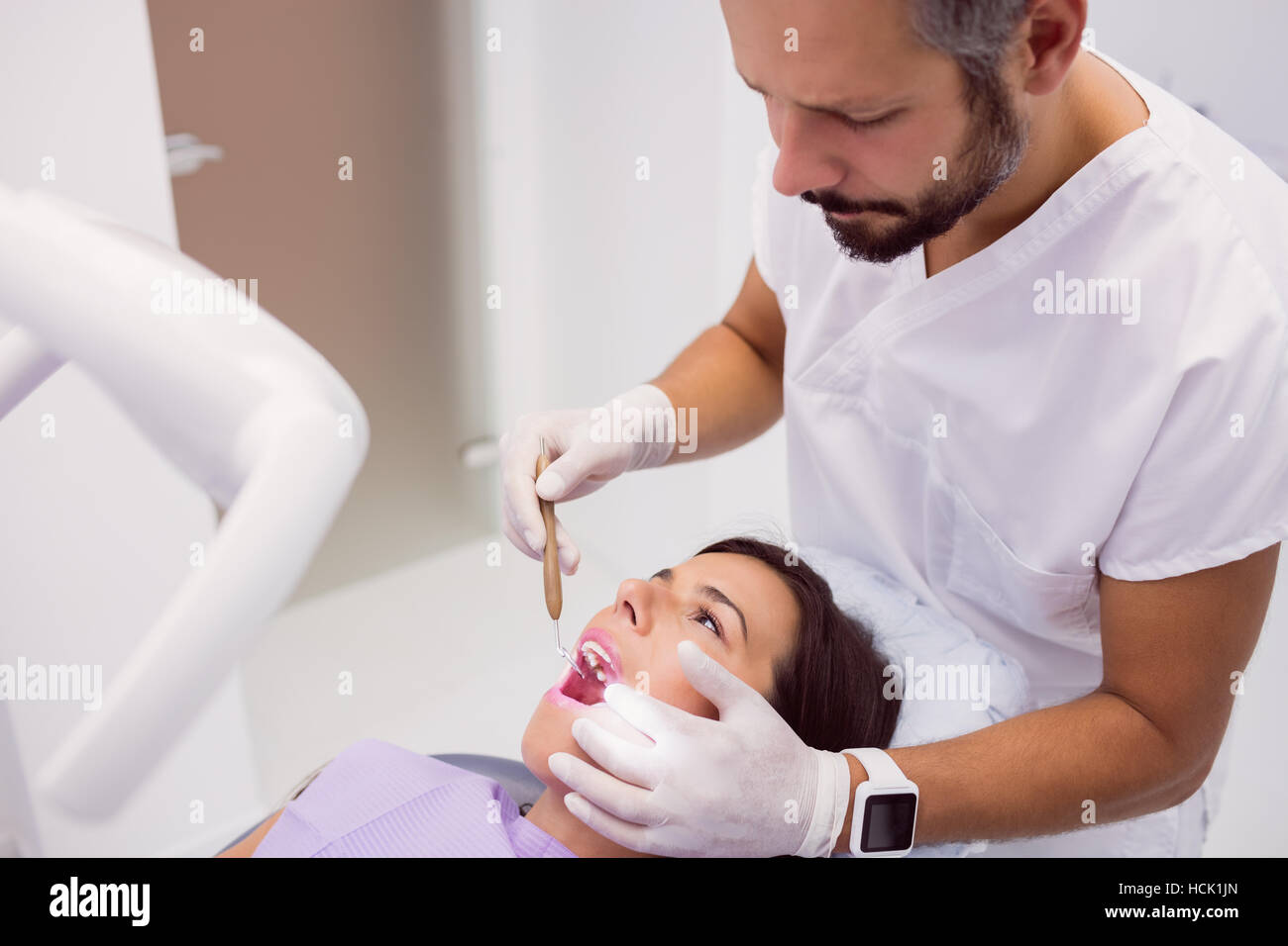 L'examen patient femme dentiste dents avec un miroir de la bouche Banque D'Images