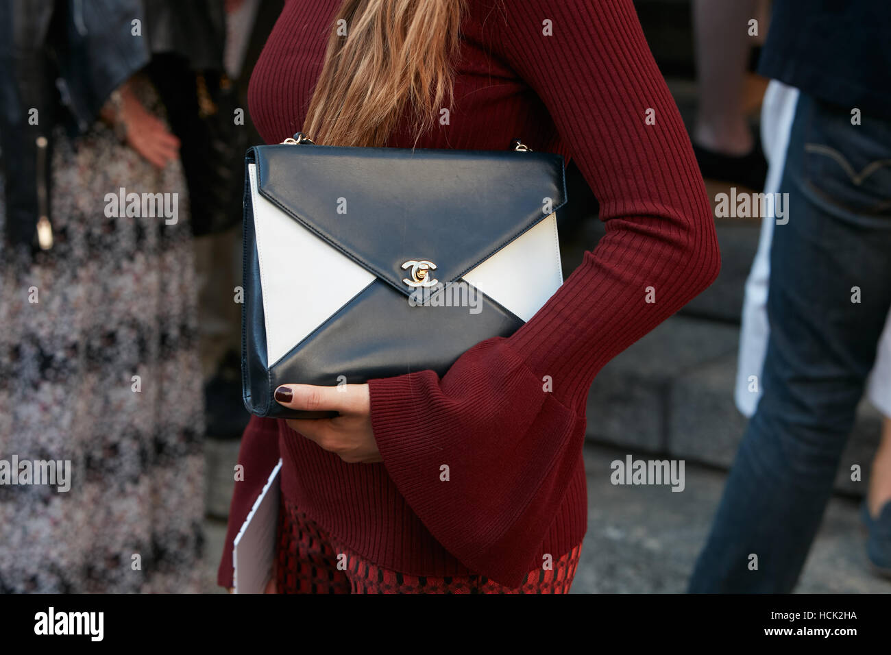 Femme avec sac Chanel noir et blanc avant de Salvatore Ferragamo fashion show, Milan Fashion Week street style, le 25 septembre dernier. Banque D'Images