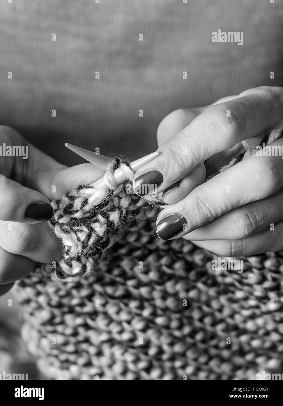 Close-up des mains tricot. Le noir et blanc Banque D'Images