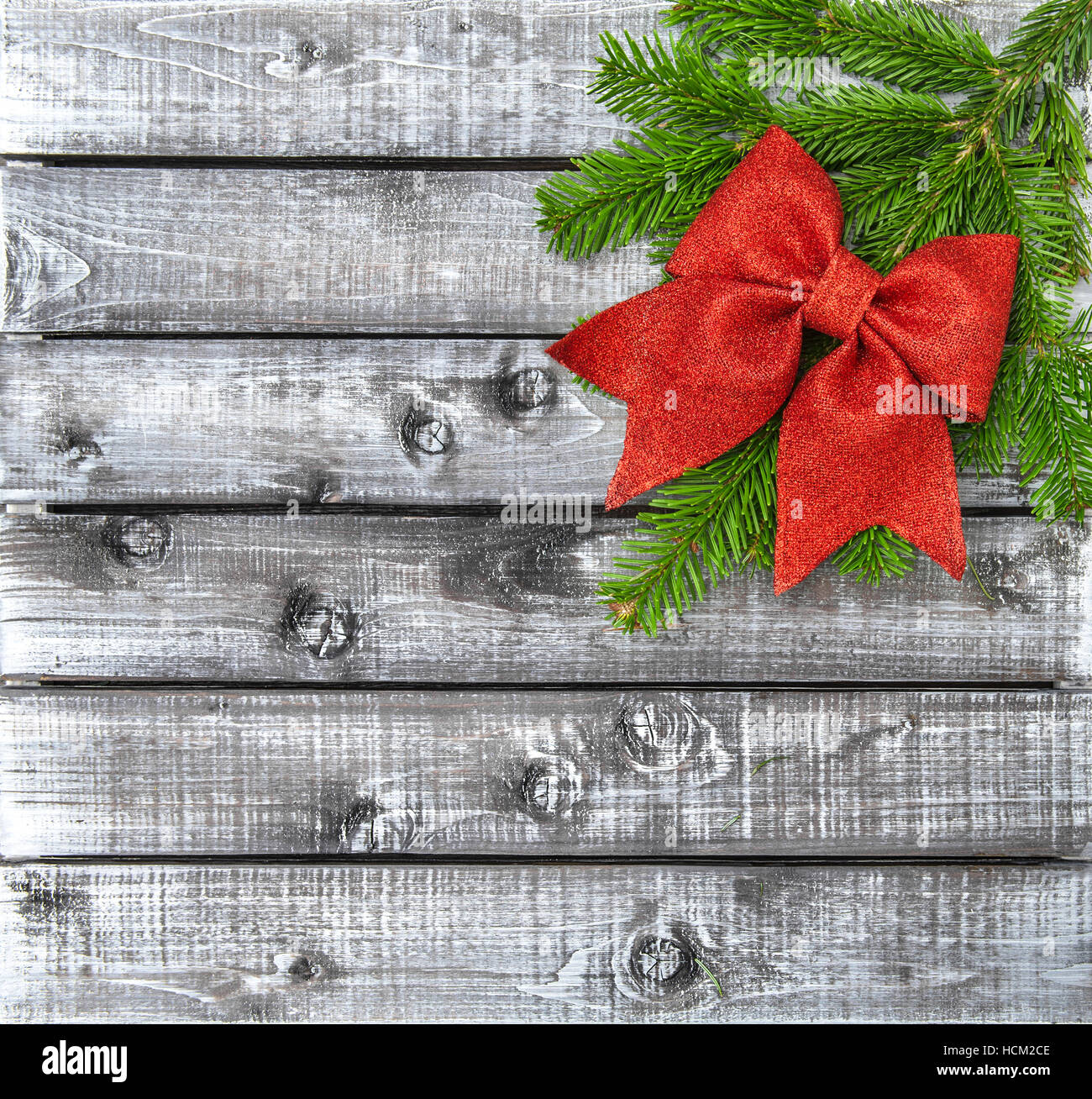 Les branches d'arbre de Noël avec Red Ribbon bow sur fond de bois rustique Banque D'Images