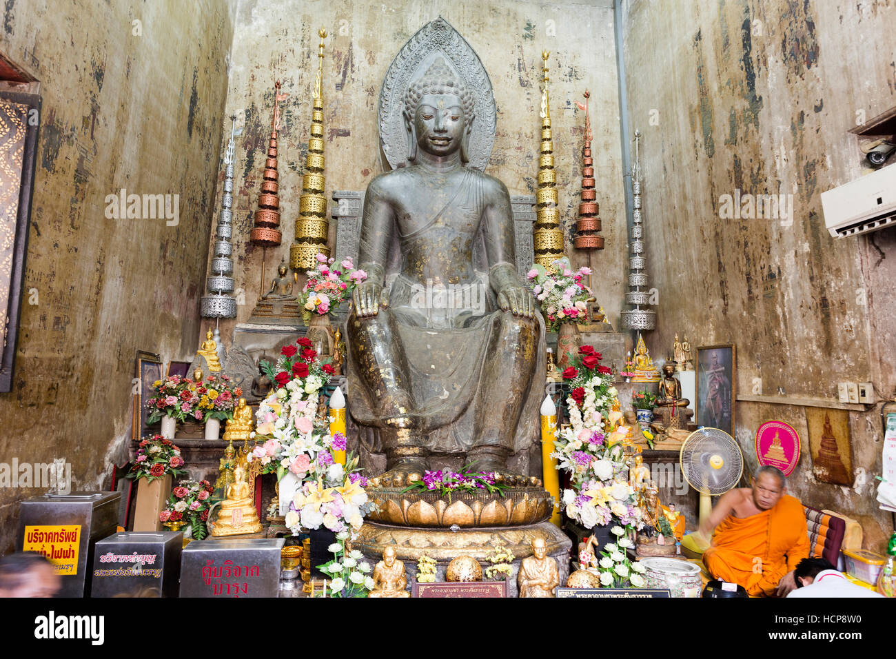 Statue d'un bouddha sculpté dans la pierre noire dans la posture européenne , assis sur une chaise, les mains sur les genoux et les deux pieds sur le sol, dans Ayuttha Banque D'Images