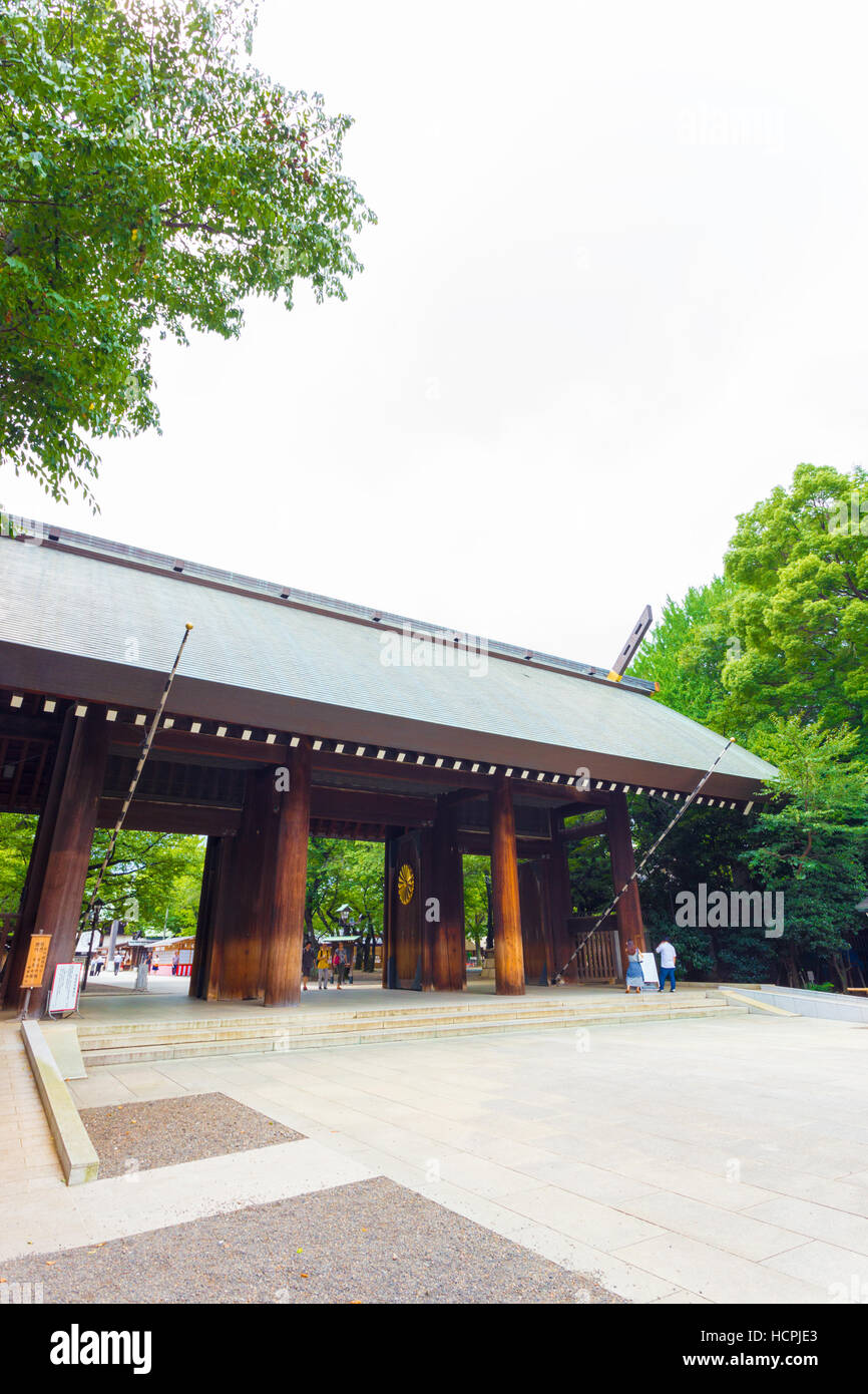 Les gens qui marchent à travers Shinmon porte en bois à l'entrée du Sanctuaire Shinto Yasukuni sur temps couvert sombre Banque D'Images