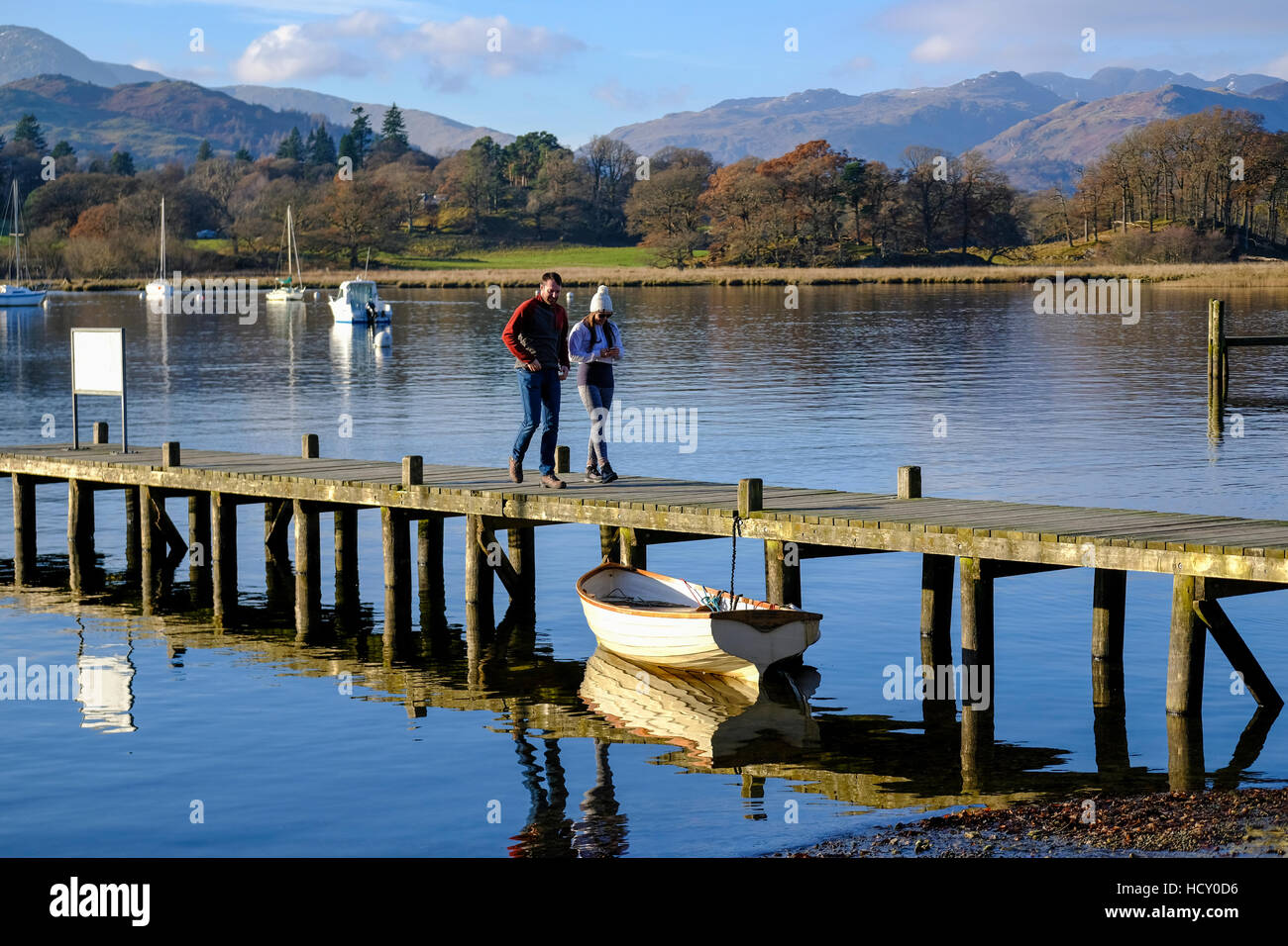 Couple en train de marcher le long du lac Windermere landing stage Banque D'Images