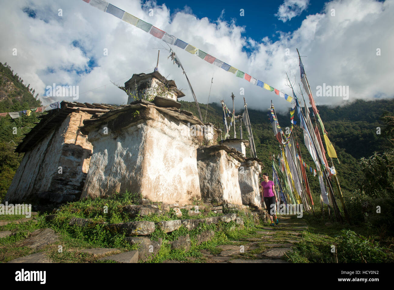 Une femme de la randonnée dans la région du patrimoine Tamang près du Langtang valley marche dernières quelques vieux chortens, Népal Banque D'Images