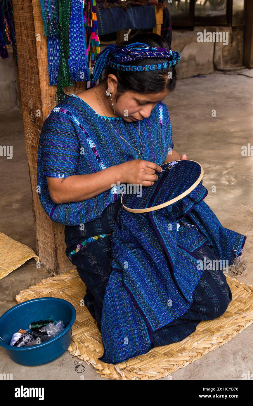 Une jeune femme en robe typique maya-main ebroiders de panneaux de tissu tissé à la main ensemble pour faire un assez grand morceau de tissu pour faire un chemisier huipil Banque D'Images