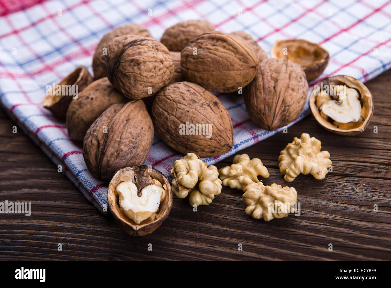 Les cerneaux de noix entiers et sur la vieille table de bois et torchon Banque D'Images