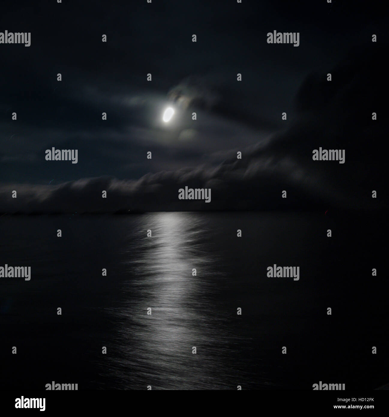 Résumé nuit image de la lune, les nuages et la mer comme l'express côtier navigue au nord le long de la côte norvégienne. Banque D'Images