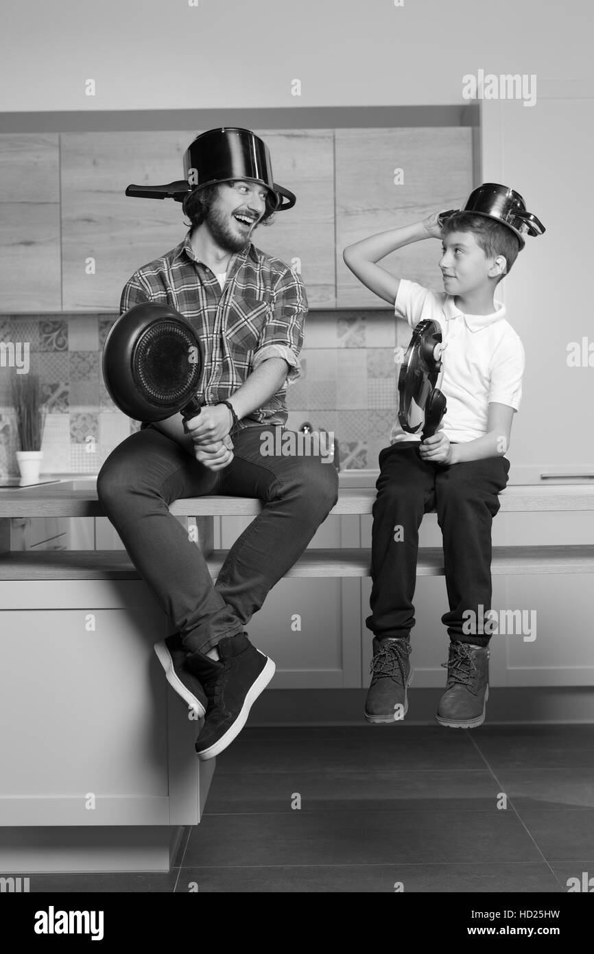 Père et enfant ont beaucoup de temps en cuisine. Père et fils s'amusant avec des pots de cuisine. Concept de famille et togethernes Banque D'Images