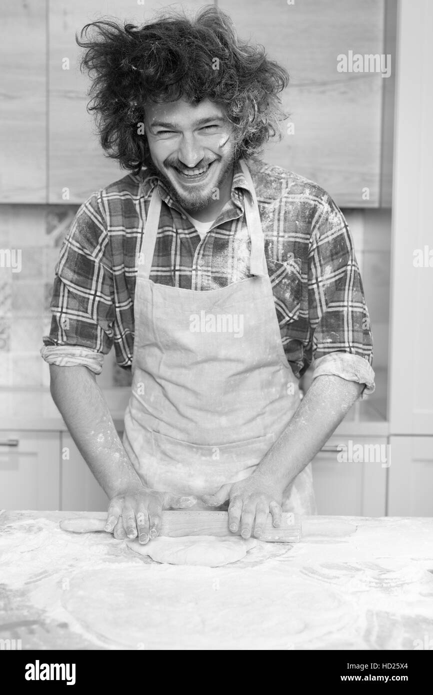 Baker prépare la pâte sur la table de cuisine à domicile Banque D'Images