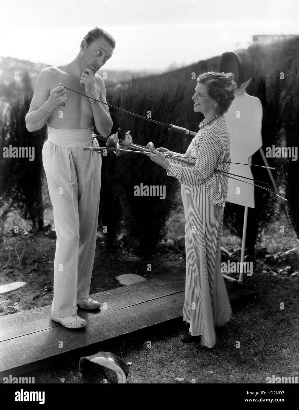 De gauche : Warren William et sa femme, Helen Barbara Nelson, au cours d'escrime à leur pratique quotidienne d'Hollywood, ca. Banque D'Images