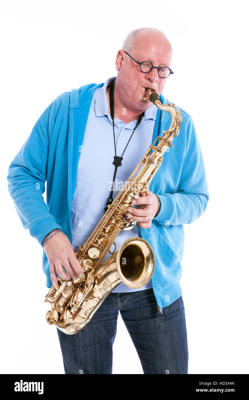 Homme d'âge moyen en bleu joue le saxophone ténor contre white background studio Banque D'Images