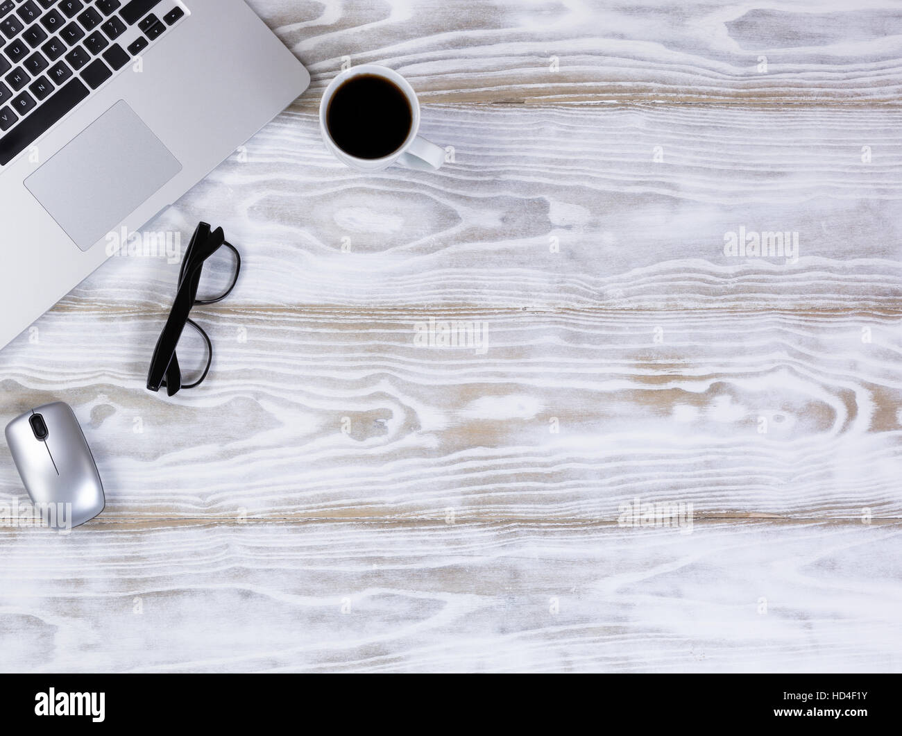 Vue de dessus d'un bureau de travail mobile avec clavier portable, café noir, lunettes de lecture, et souris sans fil blanc rustique bureau. Banque D'Images