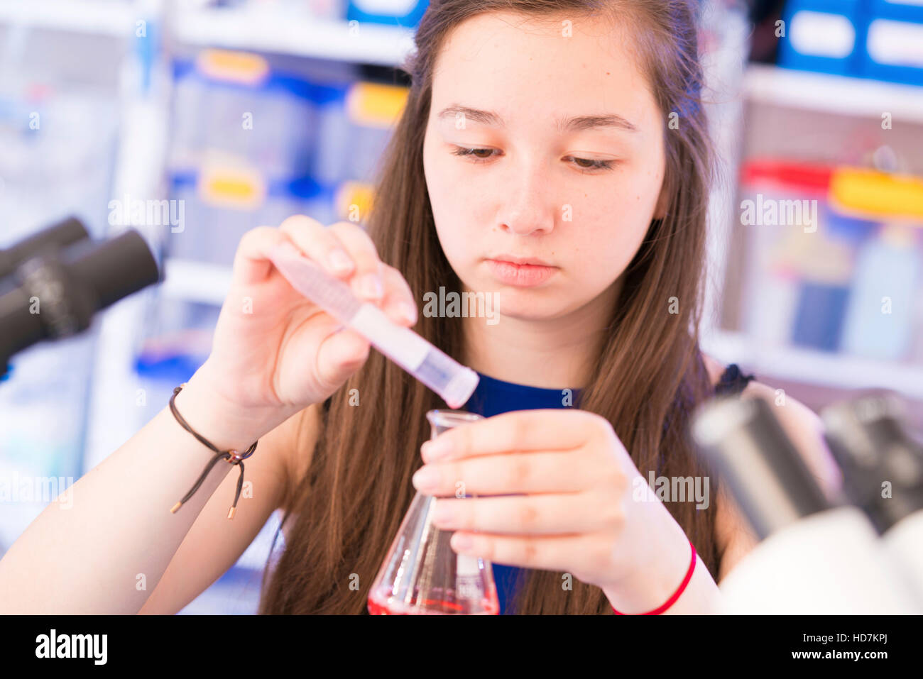 Parution du modèle. Girl pouring liquid into erlenmeyer chimique en laboratoire. Banque D'Images