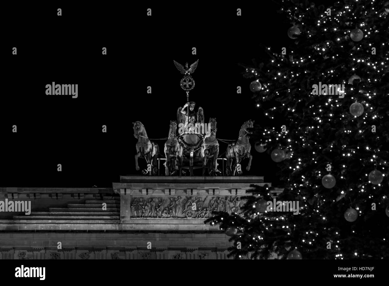 Un fragment de la porte de Brandebourg (Quadrige close-up) et d'un fragment d'un arbre de Noël dans l'avant-plan. Noir et blanc. Banque D'Images