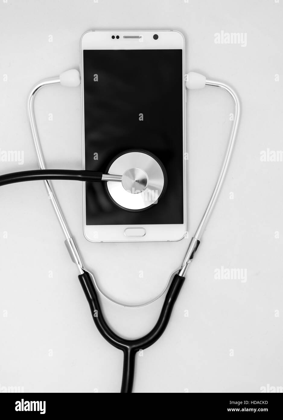 Stéthoscope médical l'outil sur la surface d'un téléphone intelligent, la composition de l'isolé sur fond blanc Banque D'Images