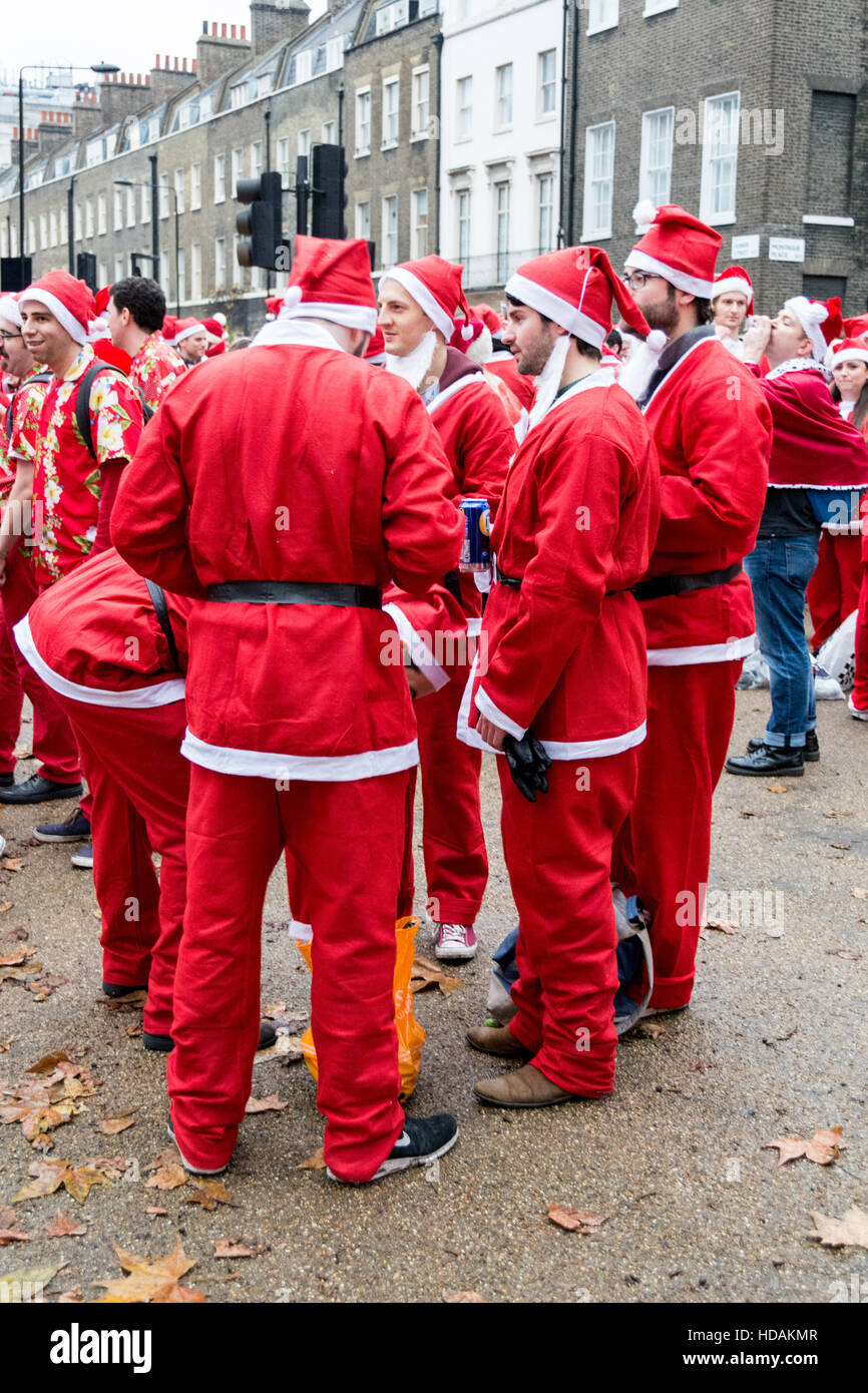 Un groupe de Santacon Santas dans les rues de Londres. Santacon est un défilé de Noël non religieux qui a normalement lieu à Londres un samedi chaque décembre. Banque D'Images