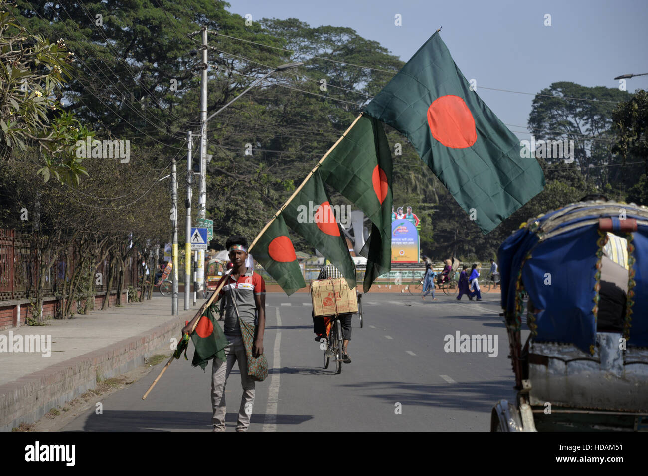 Dhaka, Bangladesh. 11Th Feb 2016. Un vendeur de rue du Bangladesh porte drapeaux nationaux du Bangladesh pour vendre au client lors de la victoire du mois de décembre à Dhaka, Bangladesh, le 10 décembre 2016. Le Bangladesh a obtenu son indépendance du Pakistan après une âpre guerre de neuf mois en 1971 dirigée par le fondateur du pays, Cheikh Mujibur Rahman, qui est célébrée chaque année le 16 décembre. Mamunur Rashid/crédit : Alamy Live News Banque D'Images