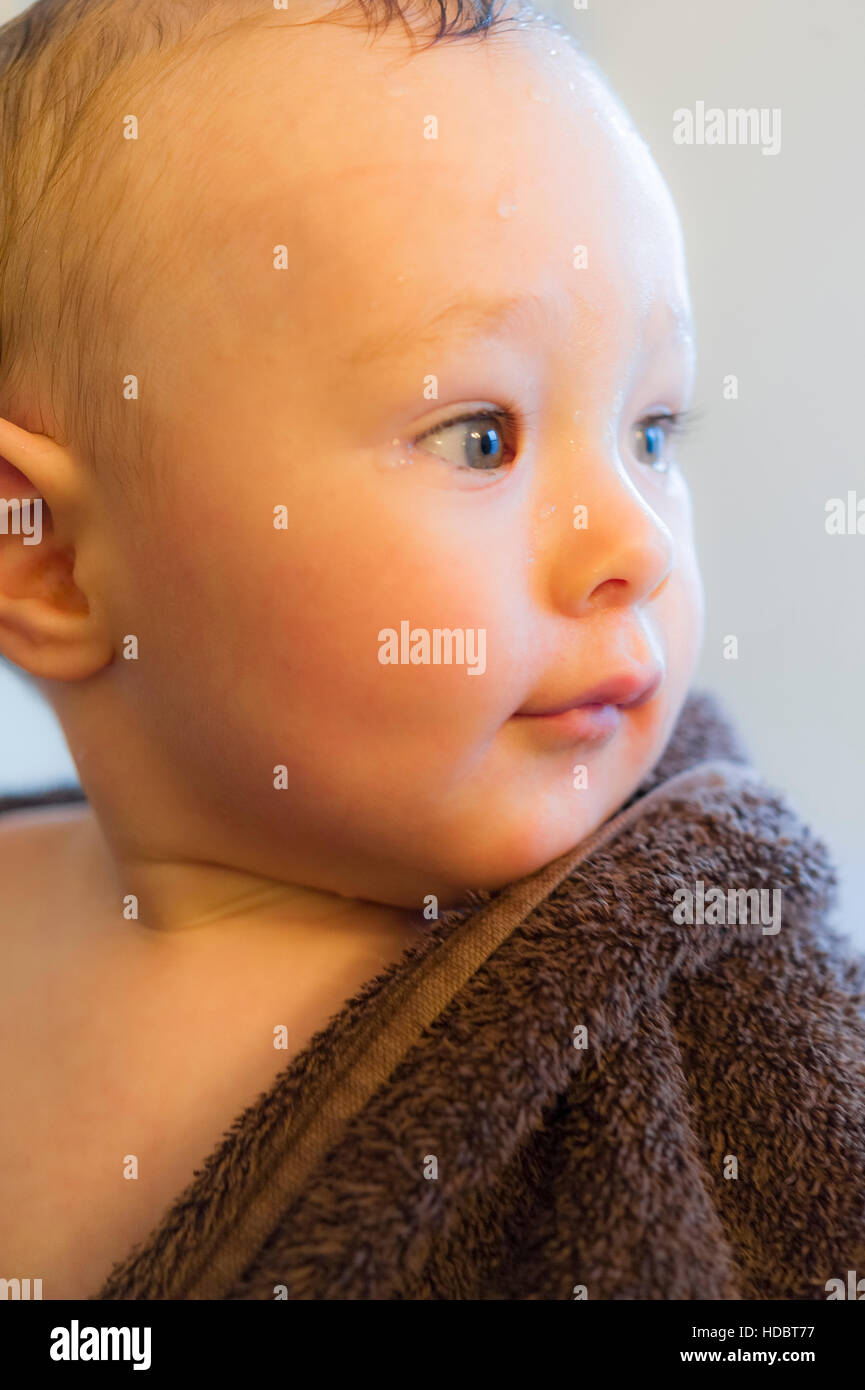 9-mois garçon couvert d'une serviette de bain Banque D'Images