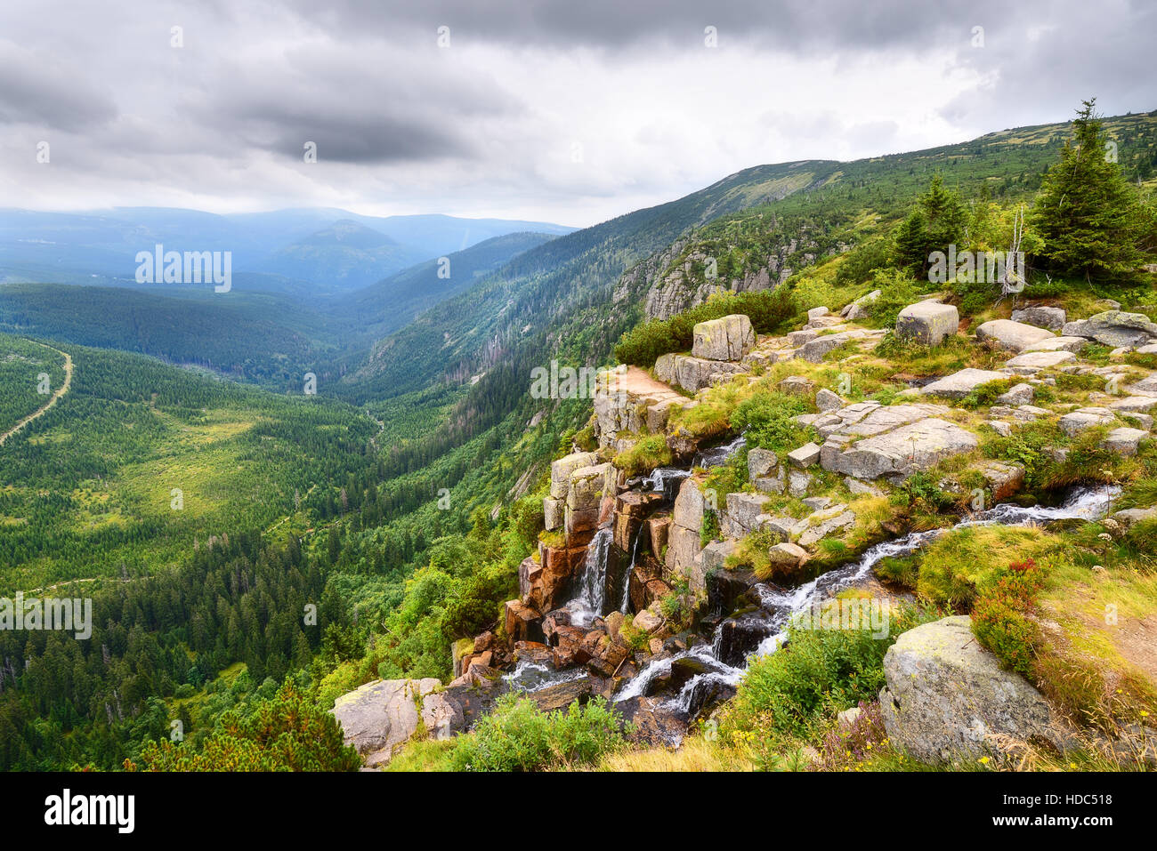 Belle cascade au-dessus de la vallée d'un vert profond des montagnes en été Banque D'Images