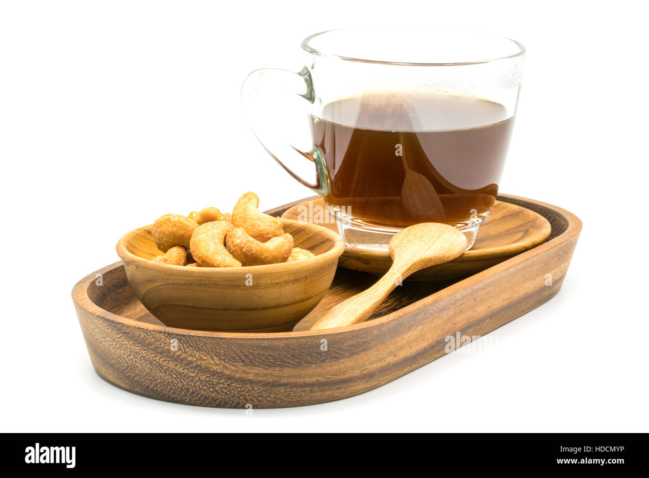 Noix de cajou salées et une tasse de café noir dans un bac sur fond blanc Banque D'Images