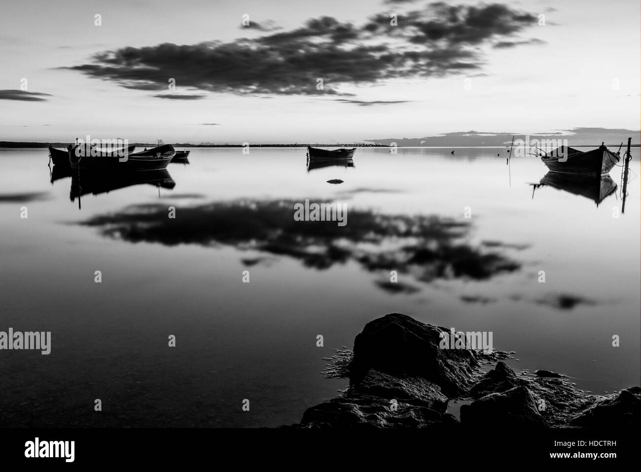 Bateaux dans le lagon au coucher du soleil. Le noir et blanc Banque D'Images