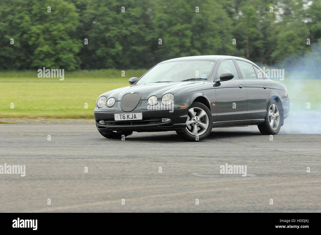 Jaguar S-type pneus voiture fumeurs et la dérive Banque D'Images