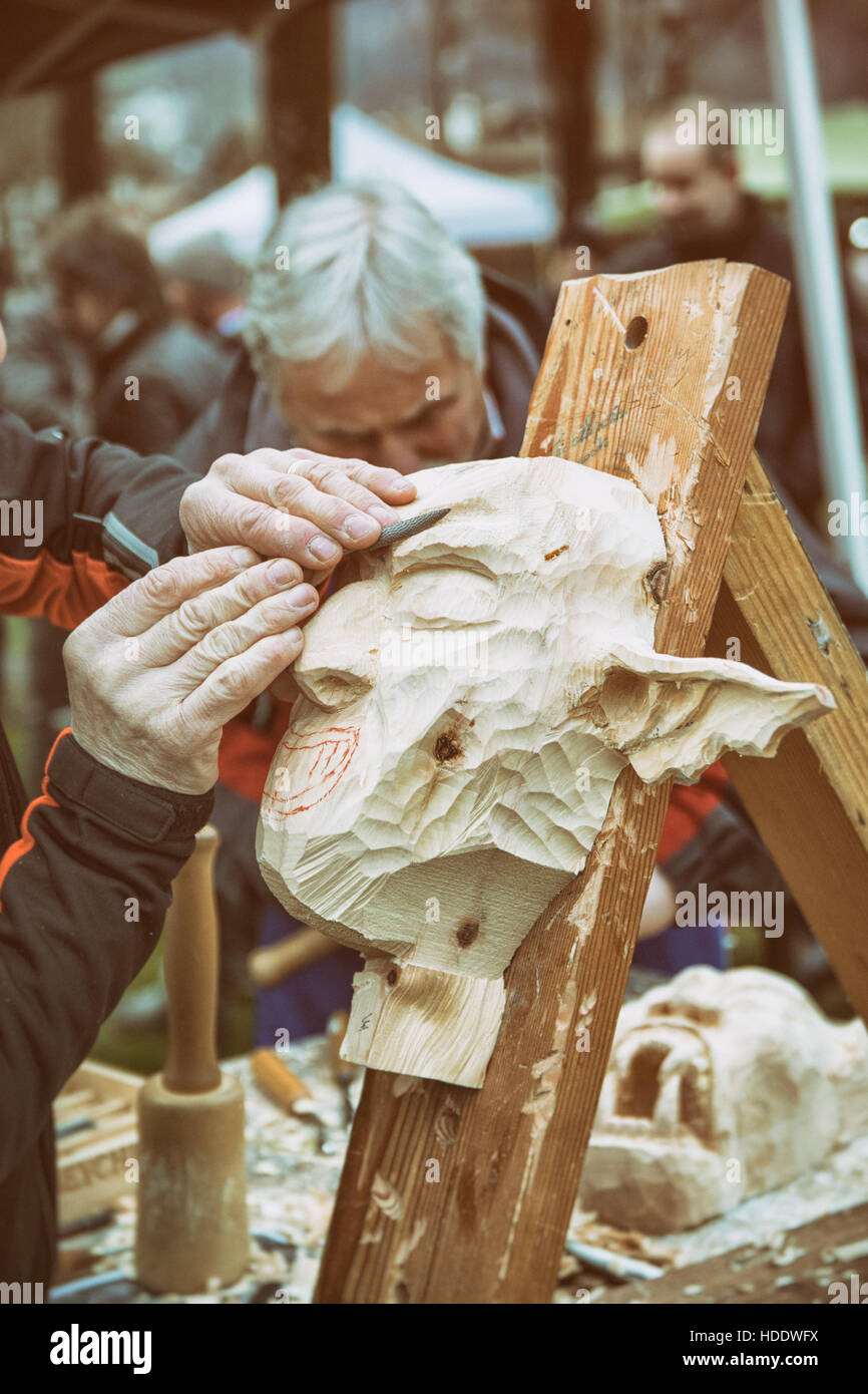 Carpenter sculpte un masque de carnaval en bois. Banque D'Images