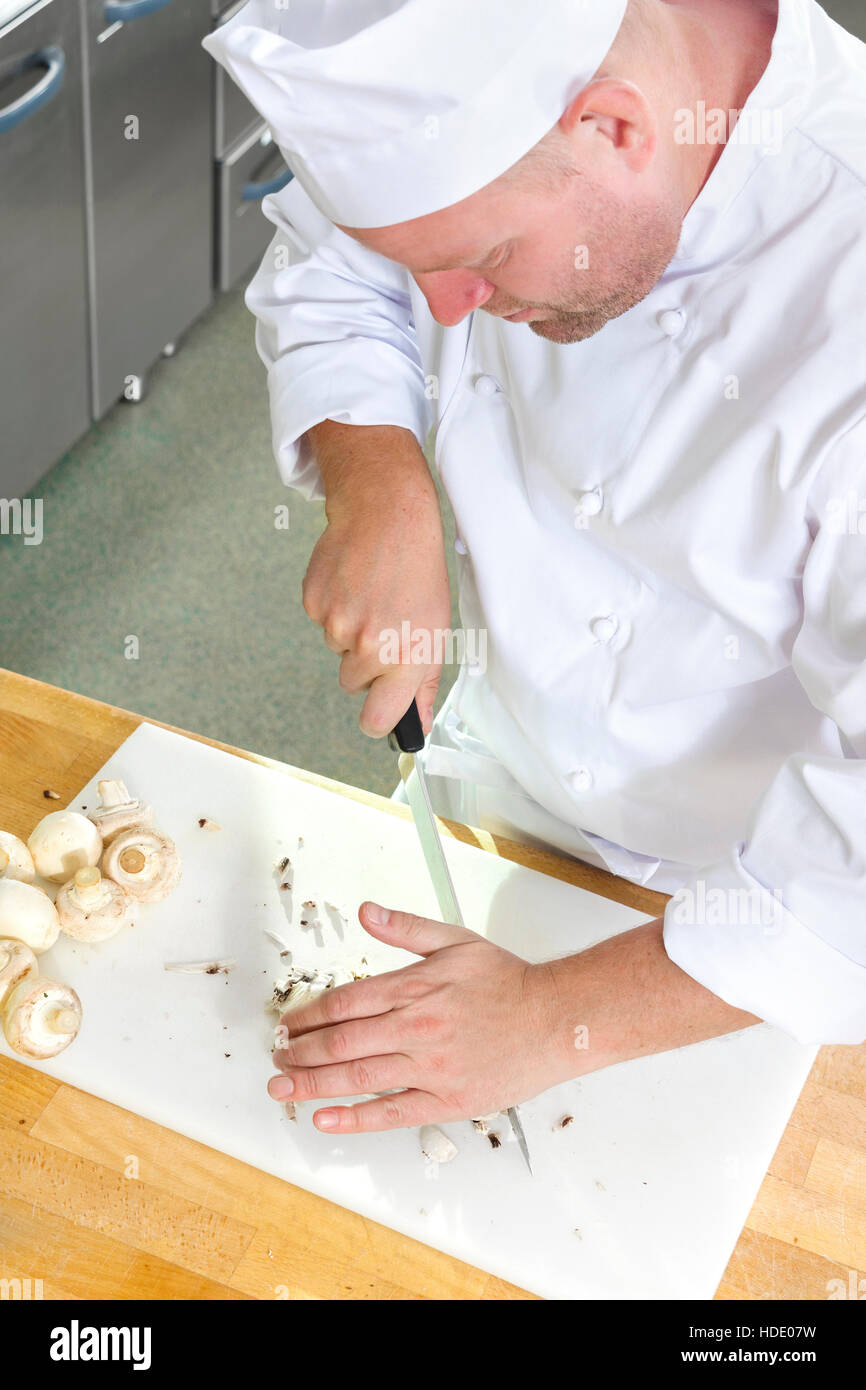 Chef professionnel la préparation de champignons dans une grande cuisine Banque D'Images