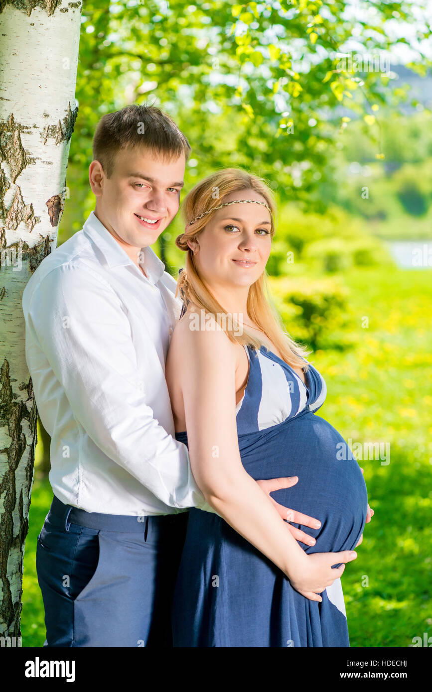 Embrassant tendrement l'homme sa femme enceinte, tourné dans le parc Banque D'Images
