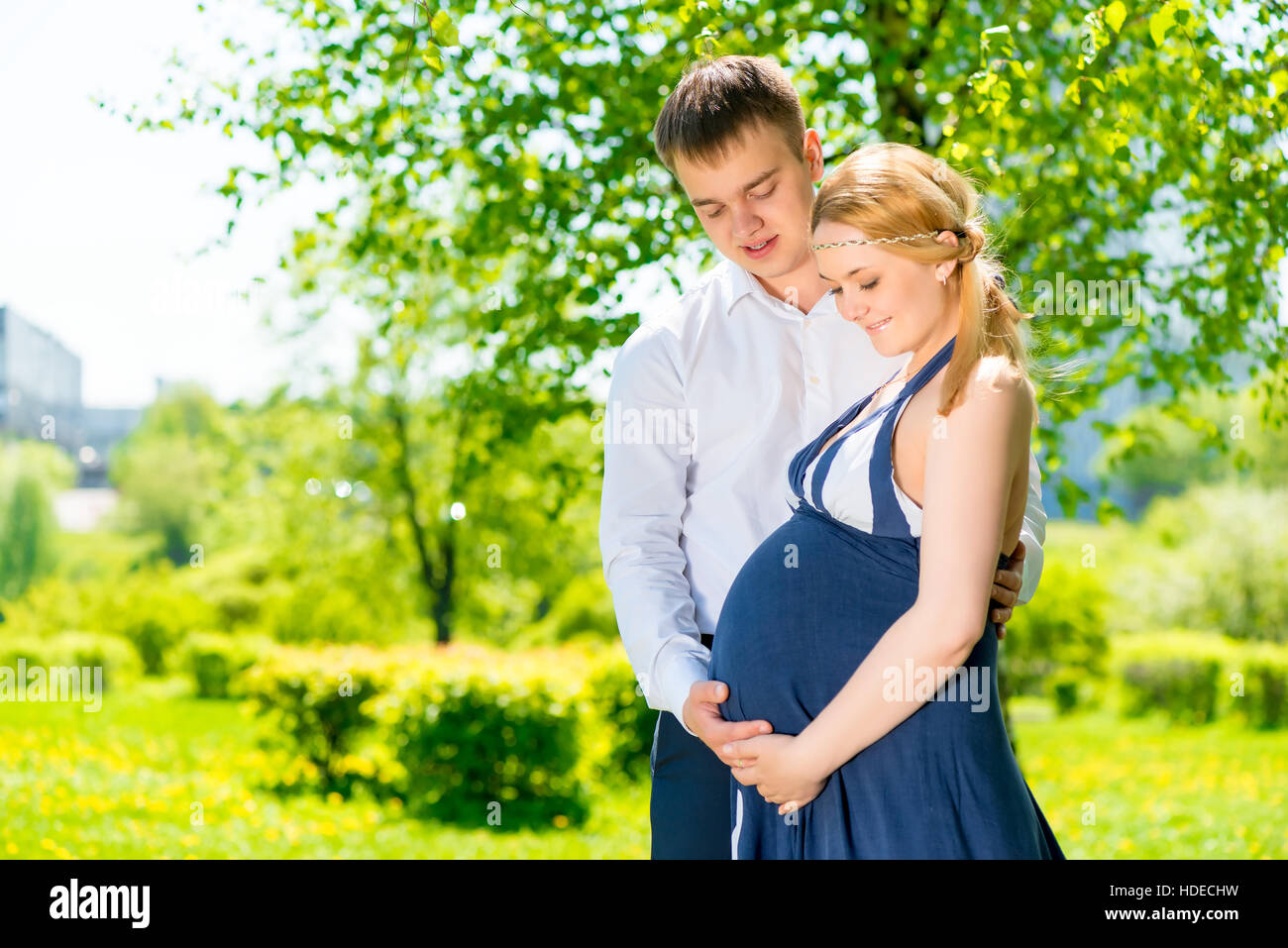 Portrait horizontal de futurs parents heureux dans le parc d'été Banque D'Images