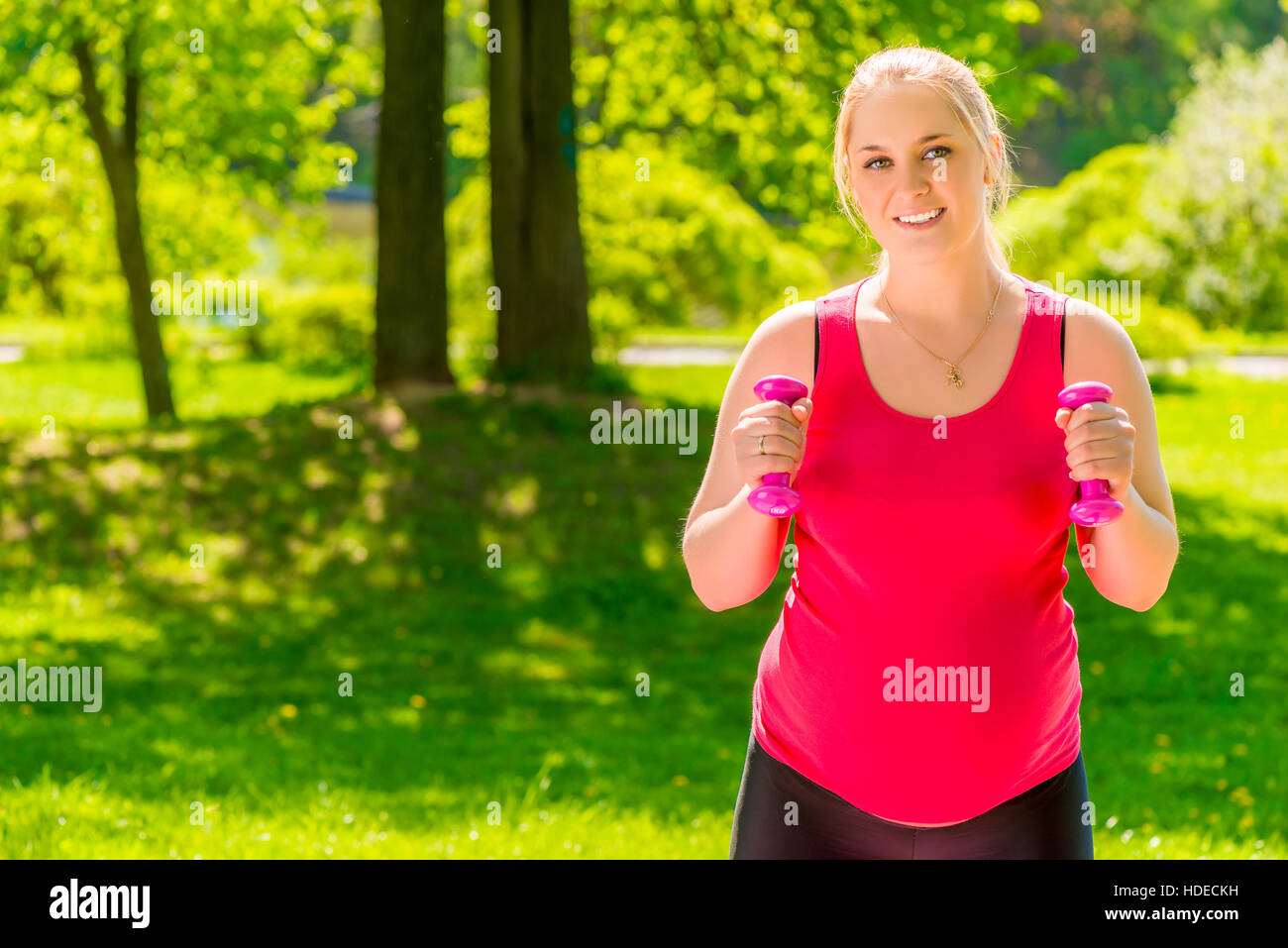 Happy pregnant woman regarder sa figure de faire les exercices dans le parc Banque D'Images