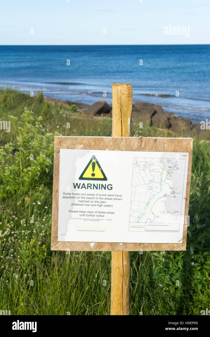 Avis d'avertissement affiché près de la réserve naturelle, Hauxley Duridge Bay, Northumberland, avertissement de sables mouvants et trous de retour sur la plage Banque D'Images