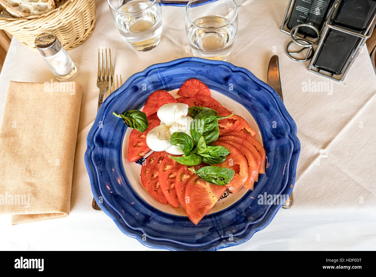 Insalata Caprese (CAPRI) Salade de tomates, mozzarella et basilic. Servi sur une plaque en céramique bleu et blanc. Banque D'Images
