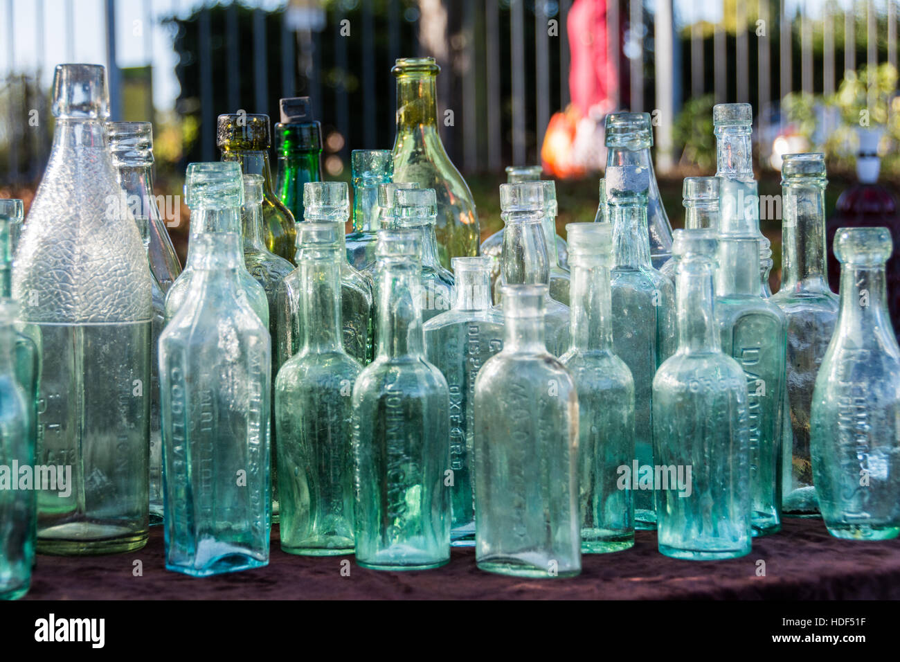 Une rangée de bouteilles en verre victorienne sur une table dans un vide grenier à Londres, Angleterre, RU Banque D'Images