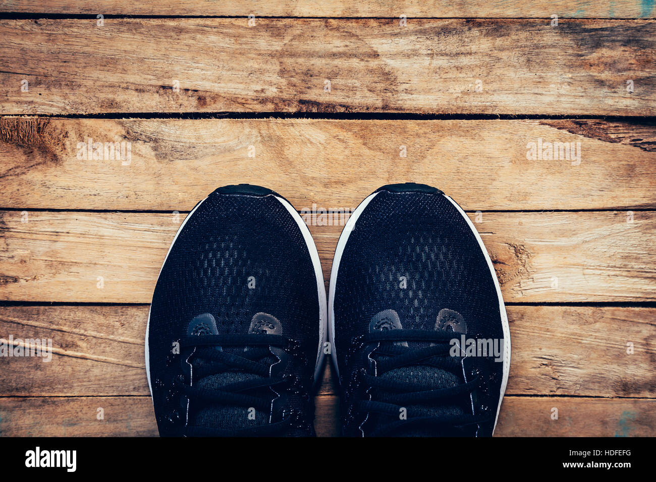 Chaussures sneaker noir et occasionnels sur fond de bois avec l'espace. Banque D'Images