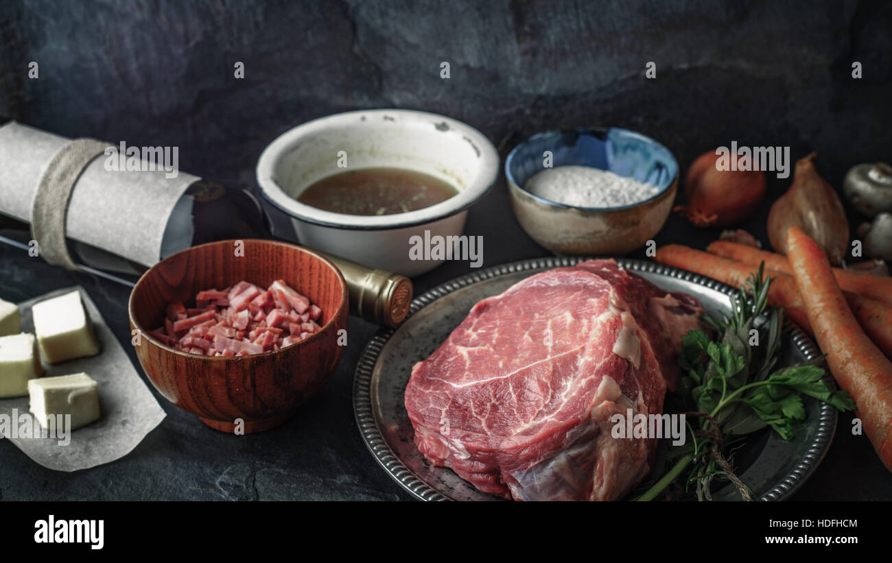 Ingrédients pour le Bœuf Bourguignon sur la pierre sombre table horizontale Banque D'Images