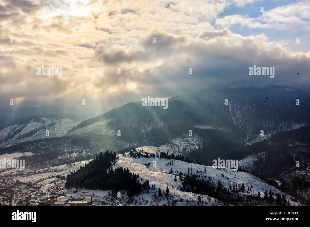 Hiver orageux ciel au-dessus de village au pied de la montagne dans le brouillard Banque D'Images