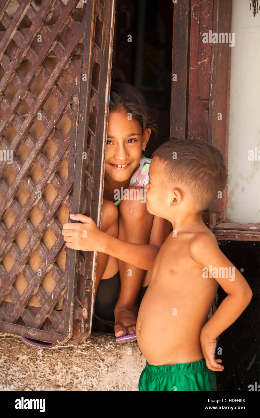 Deux enfants, l'un se cache derrière une porte dans le centre de La Havane, Cuba. Banque D'Images