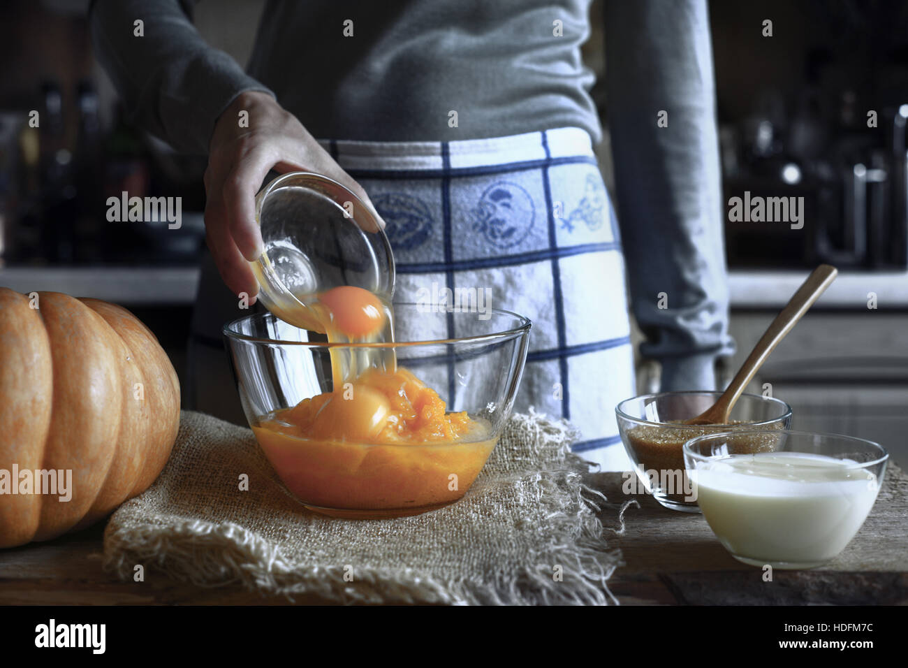 L'ajout d'oeufs dans la purée de potiron dans le bol en verre Banque D'Images