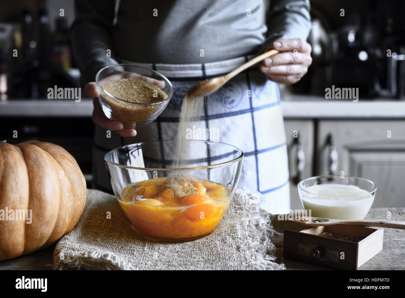 Ajouter le sucre brun dans la pâte à gâteau de vidage de citrouille Banque D'Images