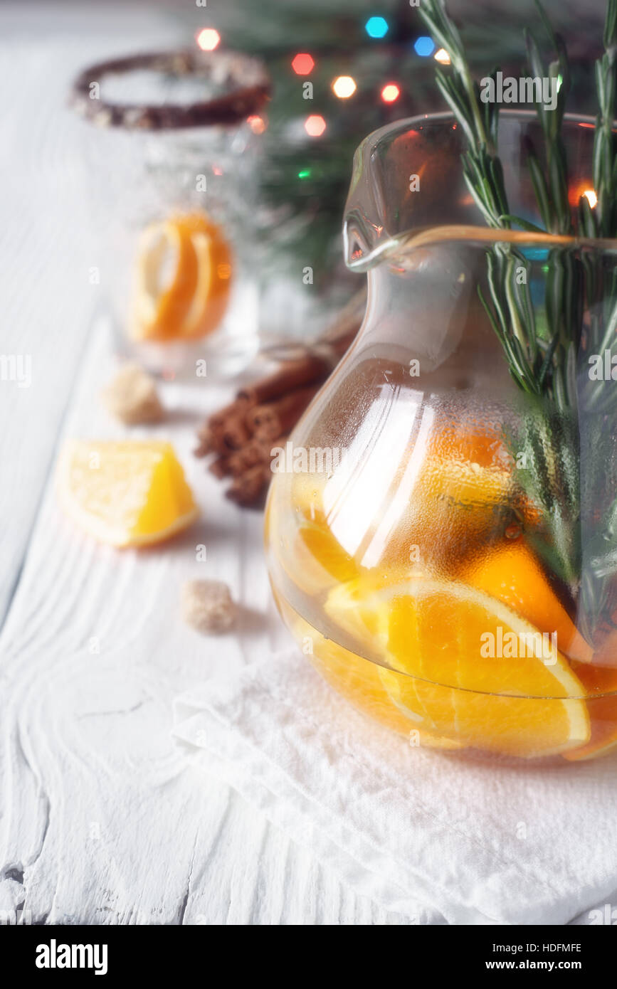 Cocktail d'agrumes dans la verseuse en verre sur la table en bois blanc Banque D'Images