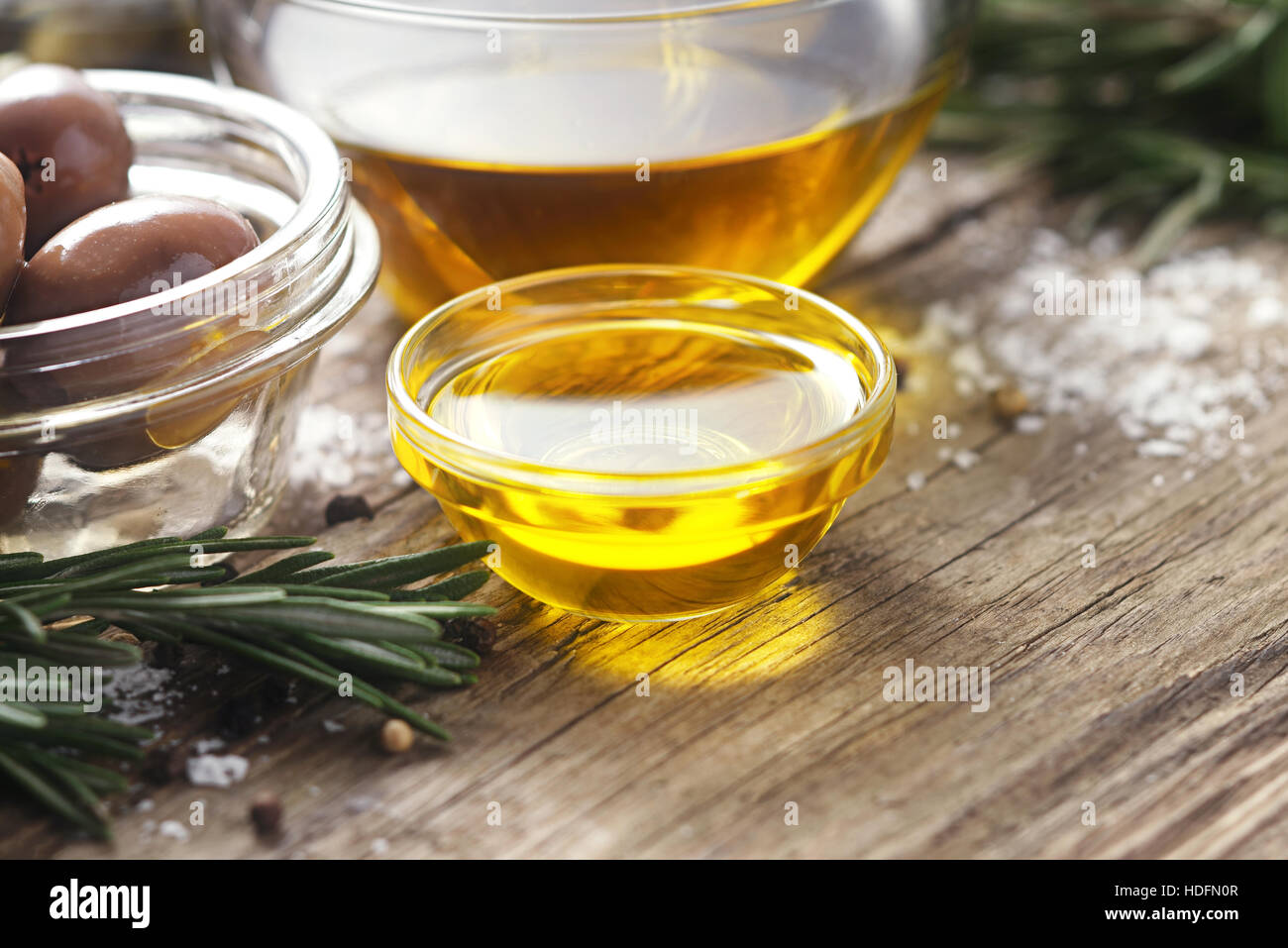 L'huile d'olive dans le bol en verre sur bois table horizontale Banque D'Images