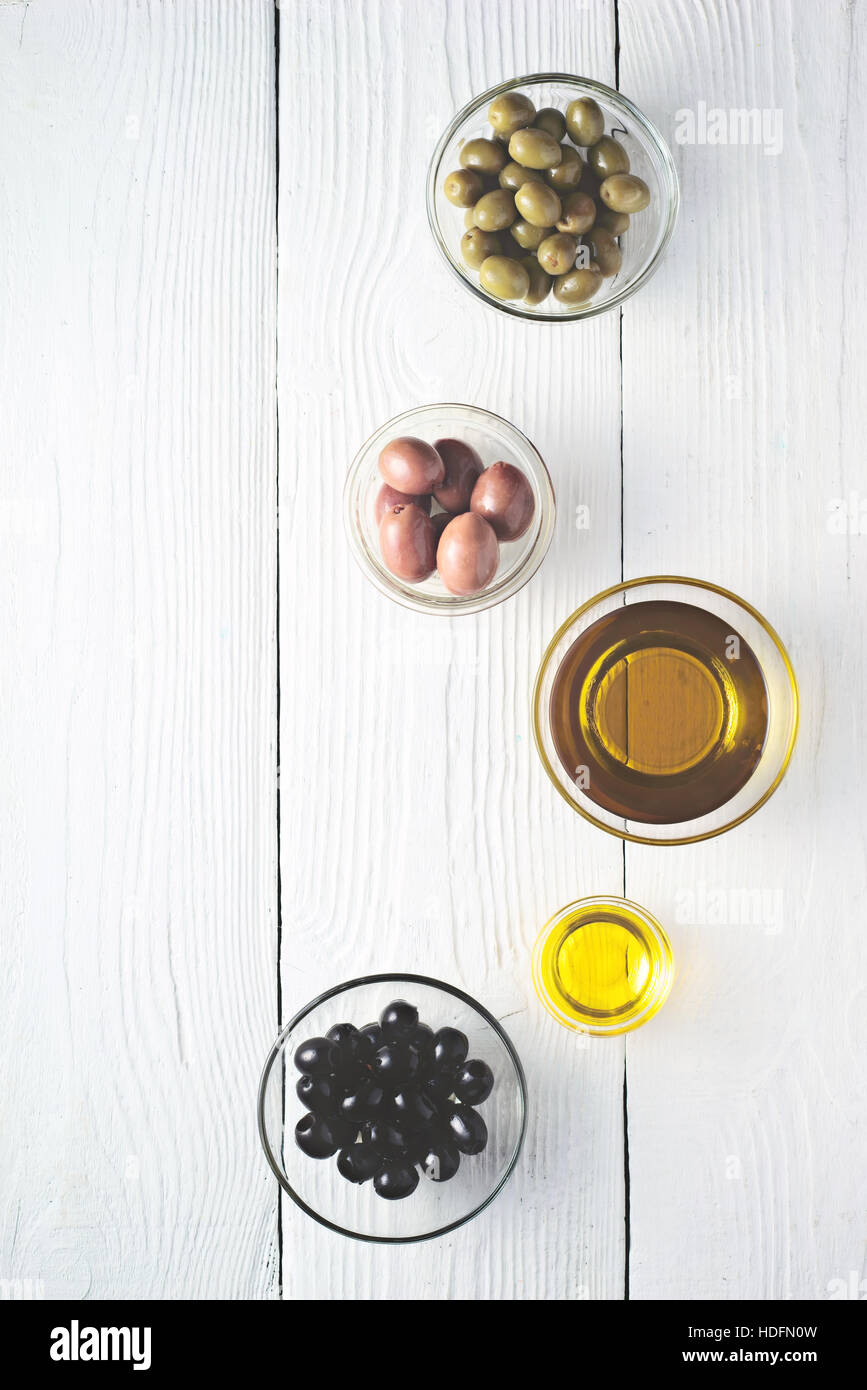 Des olives et huile d'olive sur la table en bois blanc Vue de dessus Banque D'Images