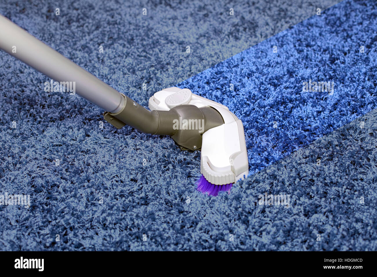 Le tuyau métallique de l'aspirateur en action - nettoyage de bande sur le tapis. Banque D'Images