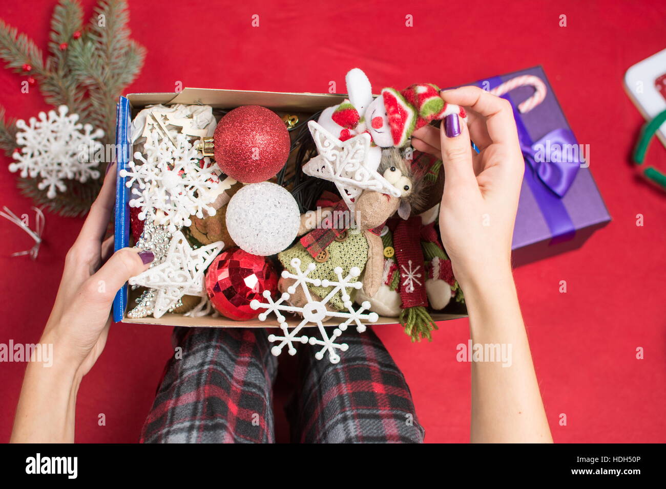 Femme tenant une boîte de décoration de Noël en pyjama Banque D'Images