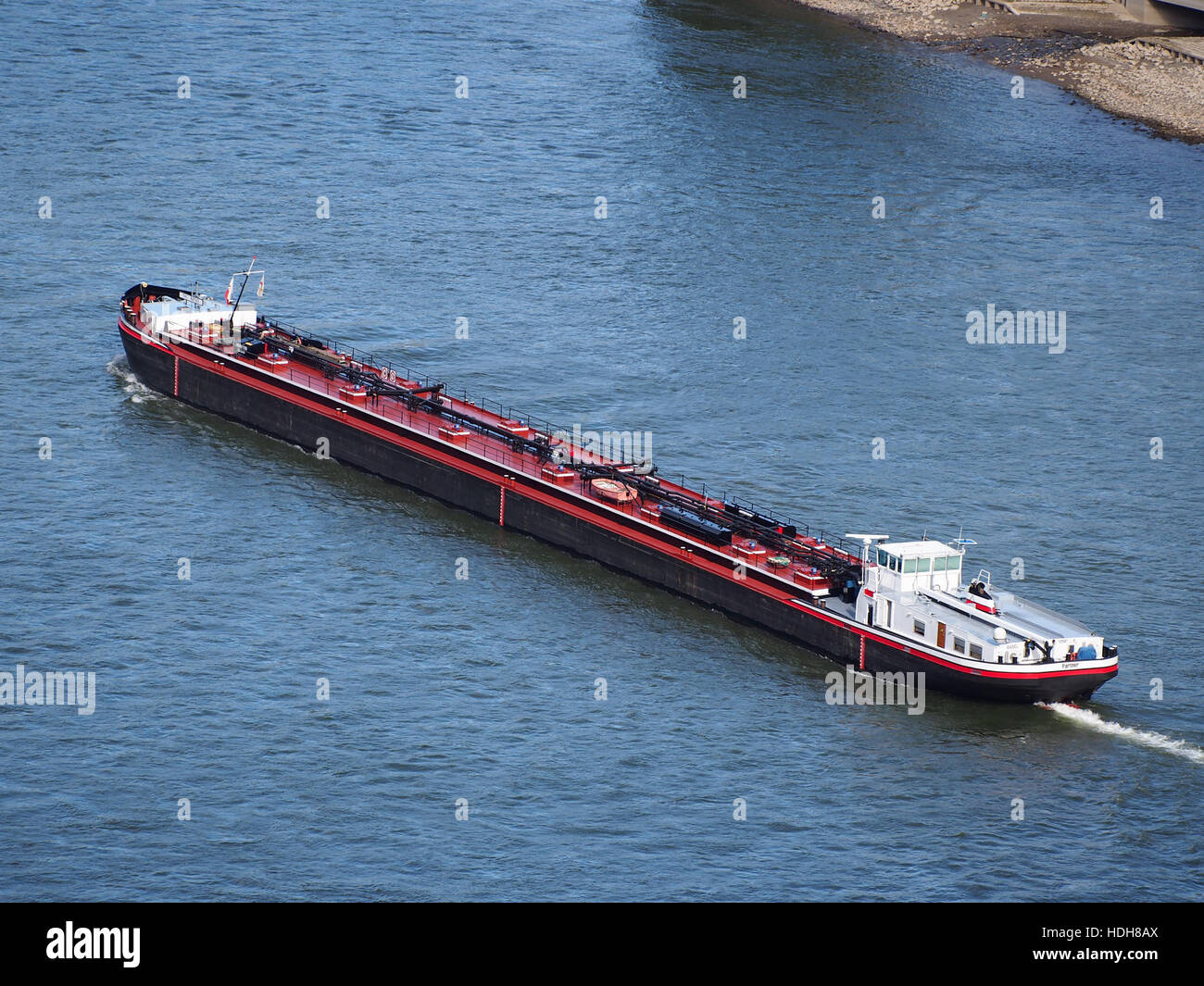 Le navire 'Partner' (ENI 02325307), construit en 1974, navigue sur le Rhin près de Sankt Goar, en Allemagne. Cette image capture le navire en mouvement, soulignant son rôle dans le transport fluvial et la beauté pittoresque de la région environnante. Banque D'Images