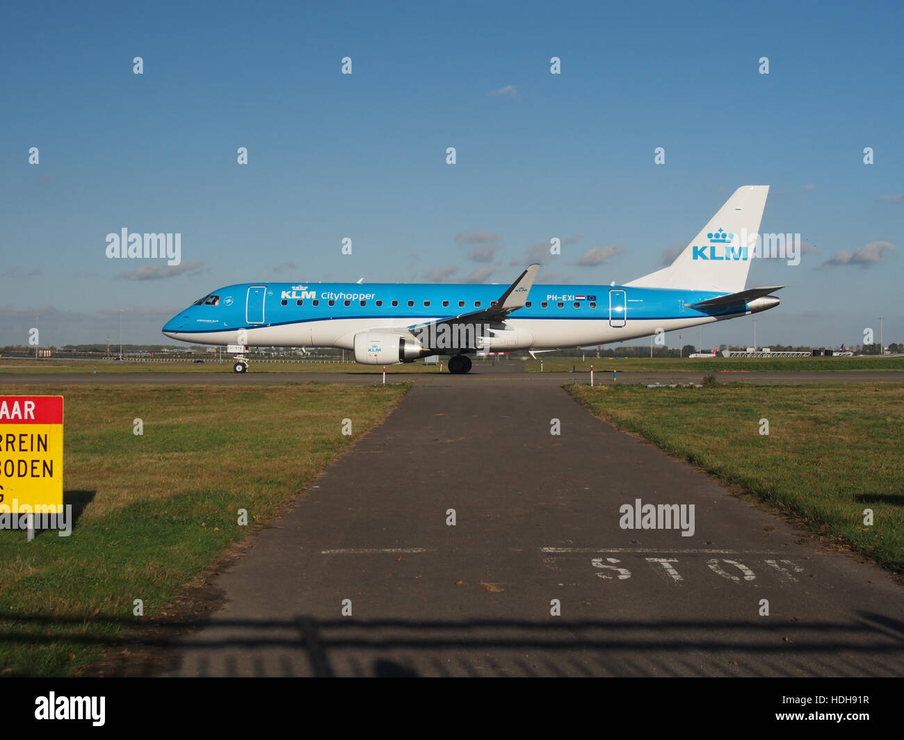 PH-EXI, un avion, est capturé au sol à l'aéroport d'Amsterdam Schiphol, en direction de la piste 36L. Cette image montre l'avion en préparation au décollage, mettant en valeur l'infrastructure aéronautique de l'aéroport. Banque D'Images